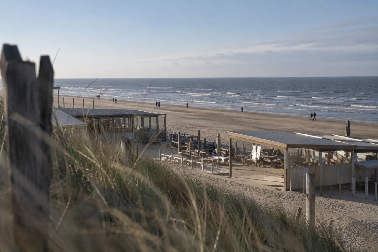 Wide sandy beach at Zandvoort with rows of beach pavilions and the North Sea horizon