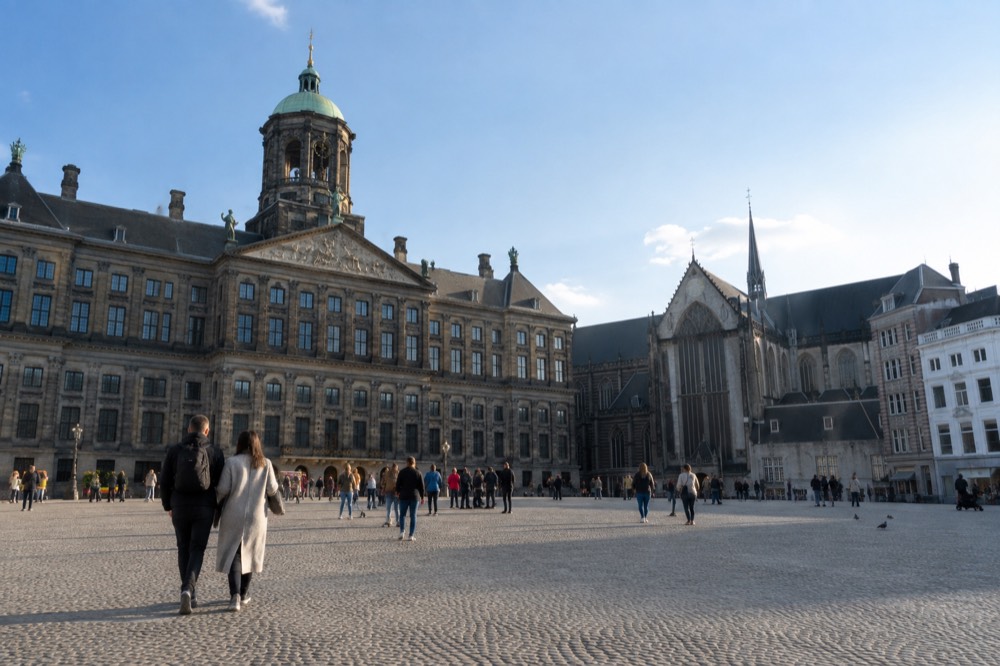 Brick facades and a quiet canal edge beside Dam Square