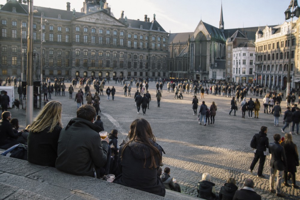 Brick facades and a quiet canal edge beside Dam Square