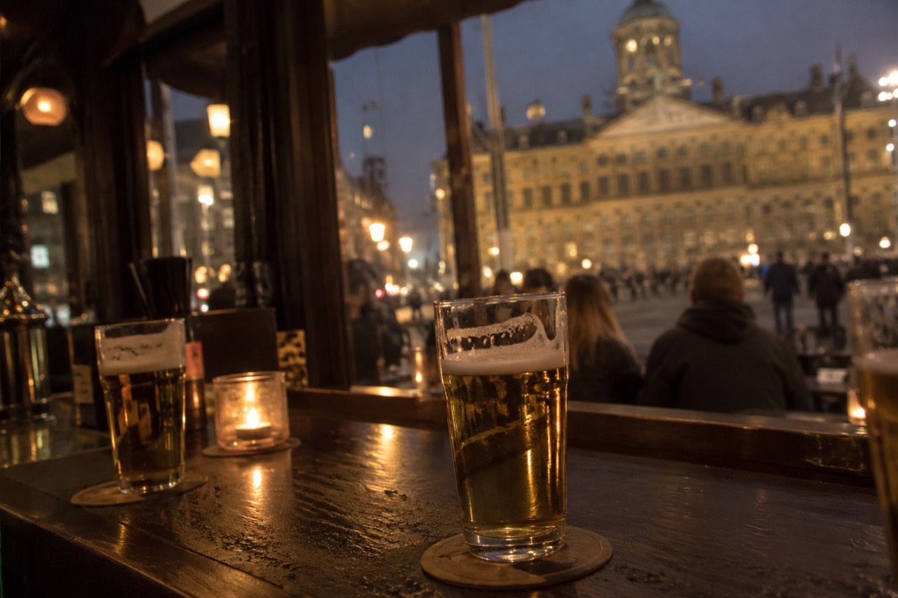 Glasses of lager on a wooden bar counter in a traditional Amsterdam café