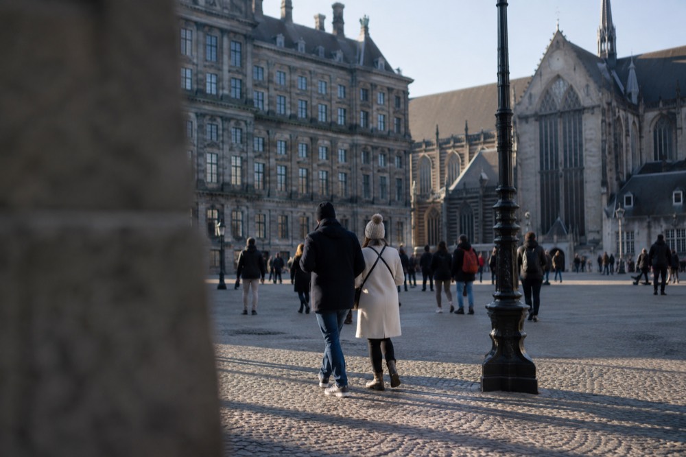 Brick facades and a quiet canal edge beside Dam Square