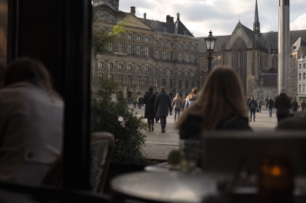 A quiet corner of Dam Square with trees overhanging the water