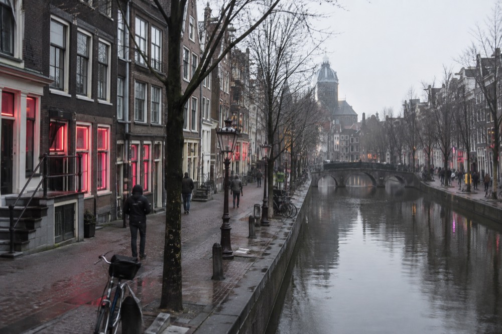 A quiet corner of Red Light District with trees overhanging the water