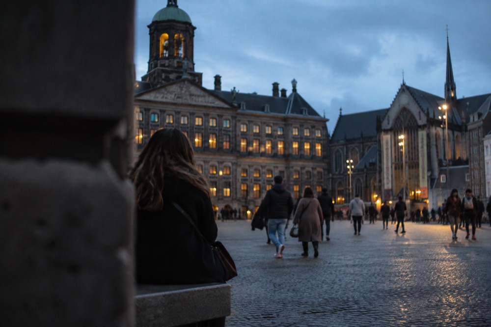 People walking past Dam Square, seen from across the street