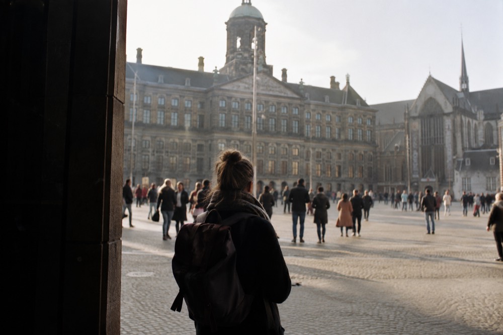 A quiet corner of Dam Square with trees overhanging the water