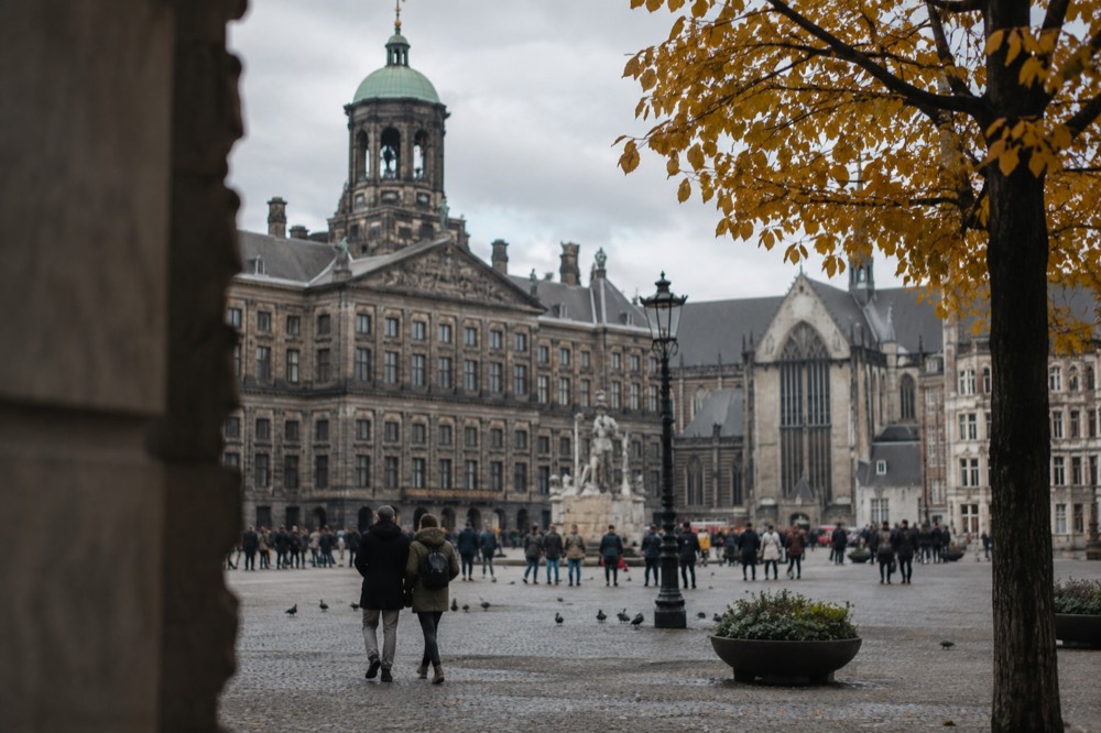 People walking past Dam Square, seen from across the street