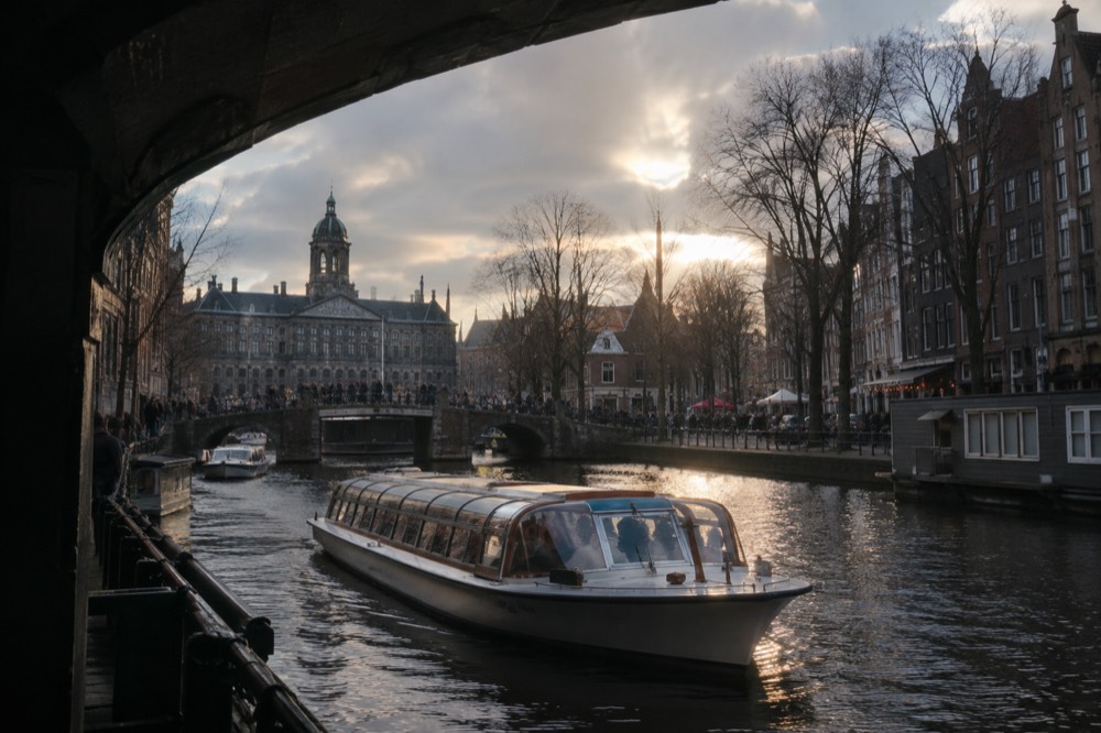 A quiet corner of Dam Square with trees overhanging the water