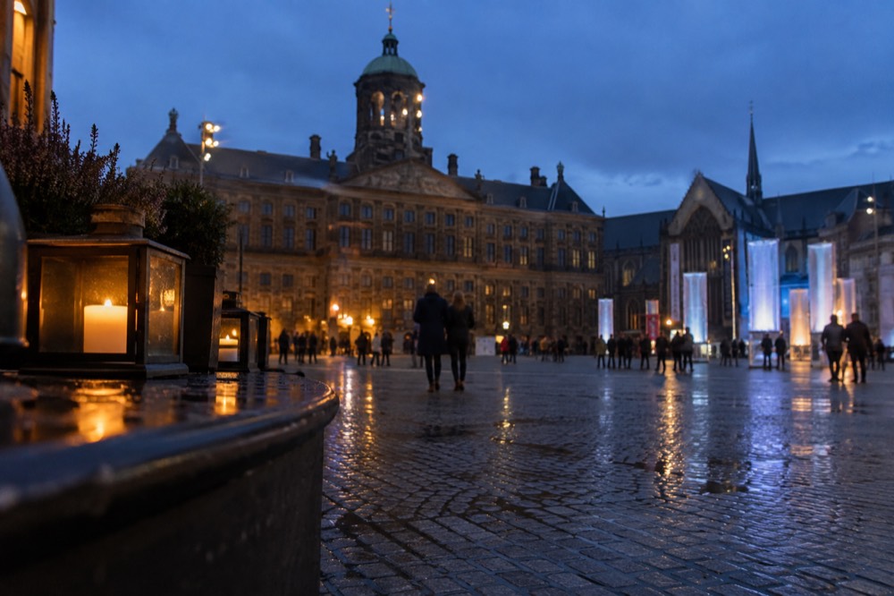 People walking past Dam Square, seen from across the street