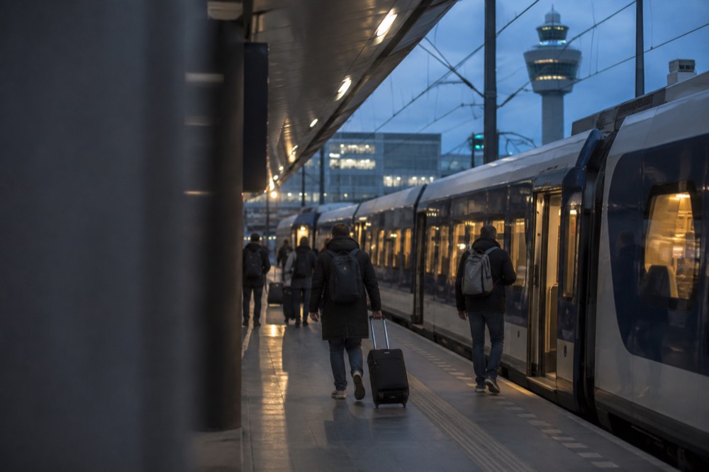 A train platform at Schiphol airport station with a sign pointing toward Amsterdam