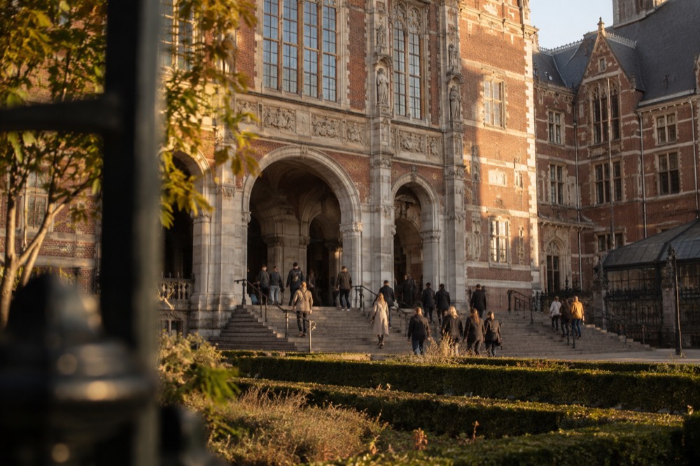 Visitors walking up the steps outside the Rijksmuseum building on a bright day