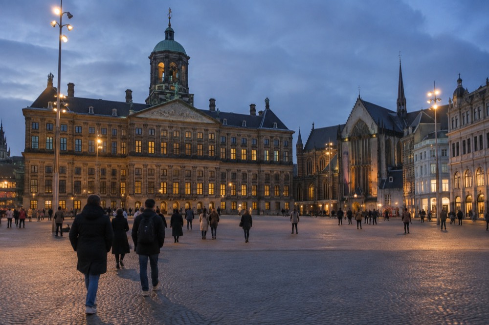 Brick facades and a quiet canal edge beside Dam Square