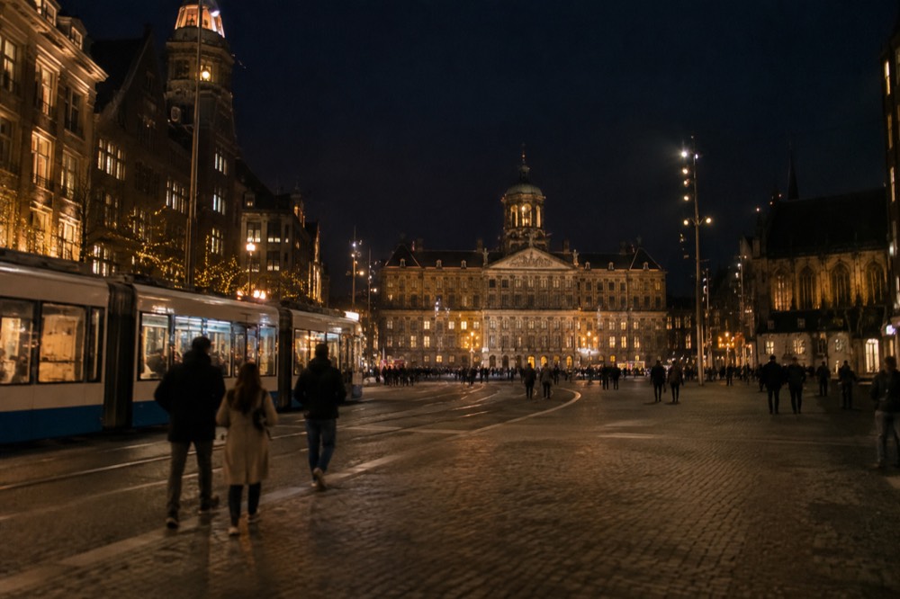 People walking past Dam Square, seen from across the street