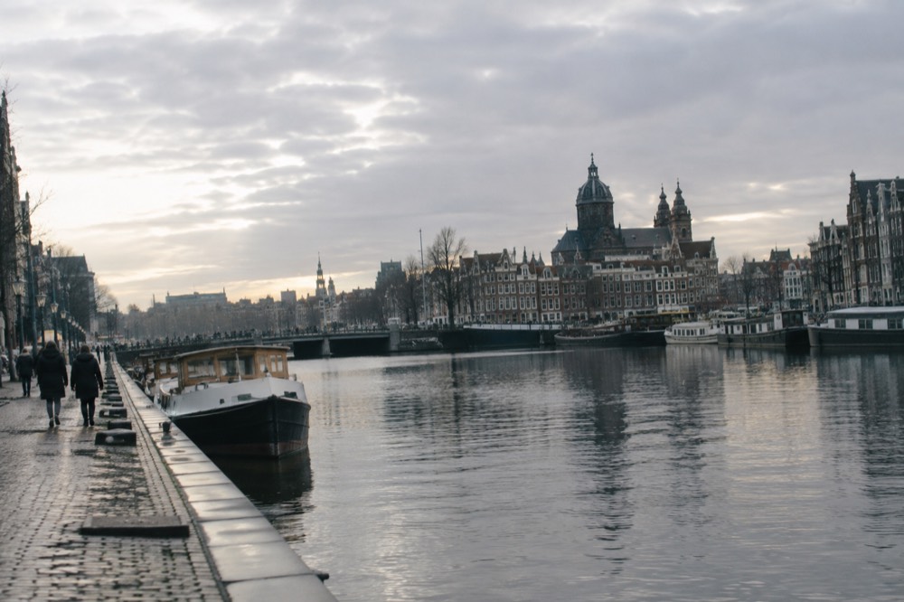 The waterfront near Dam Square under a broad grey northern sky