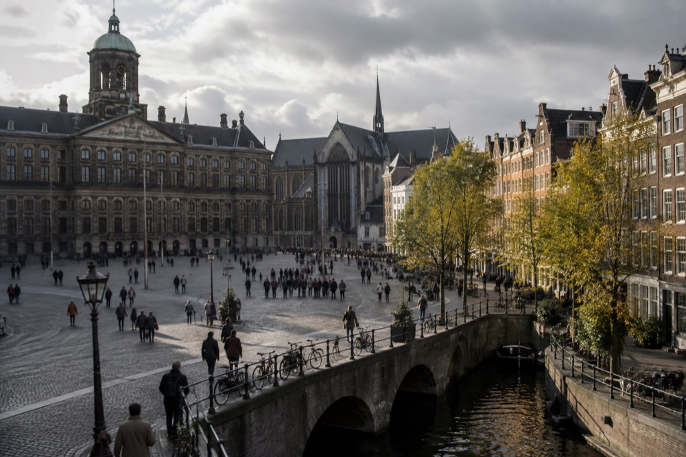 Brick facades and a quiet canal edge beside Dam Square