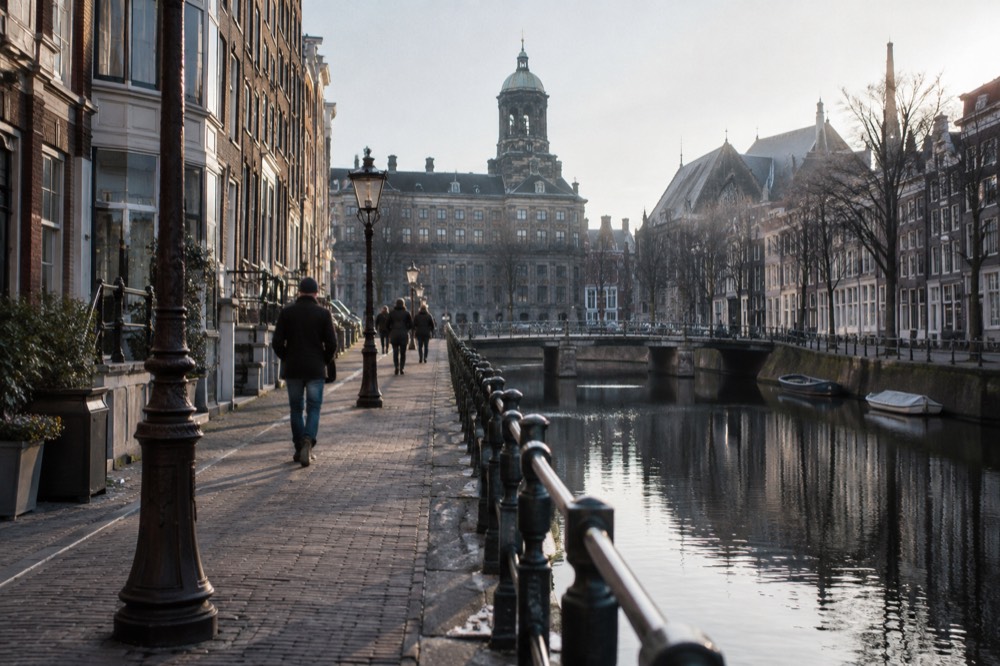 Brick facades and a quiet canal edge beside Dam Square