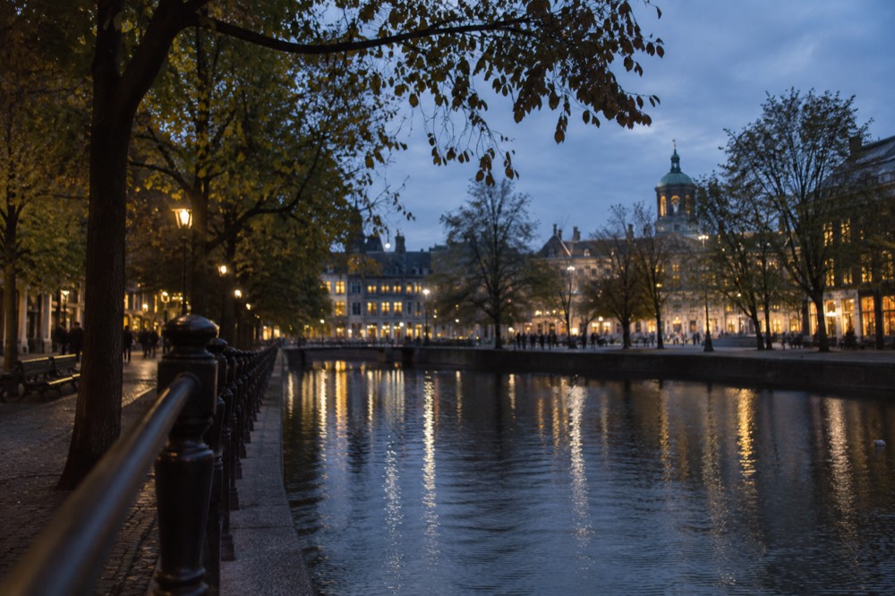 A quiet corner of Dam Square with trees overhanging the water