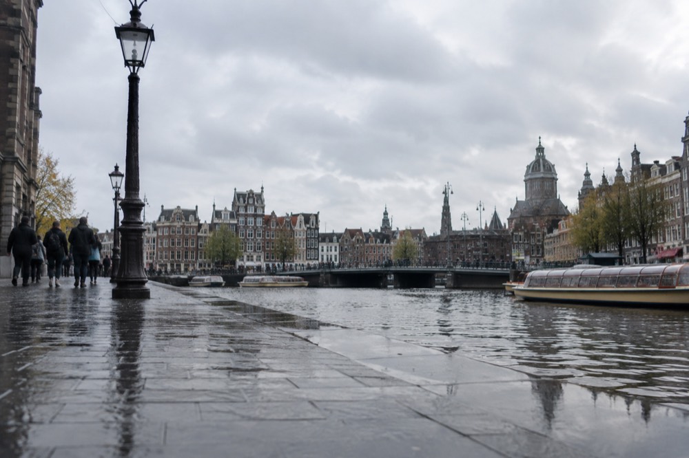 The waterfront near Dam Square under a broad grey northern sky