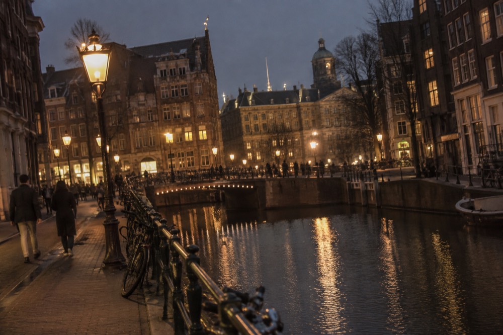 Brick facades and a quiet canal edge beside Dam Square