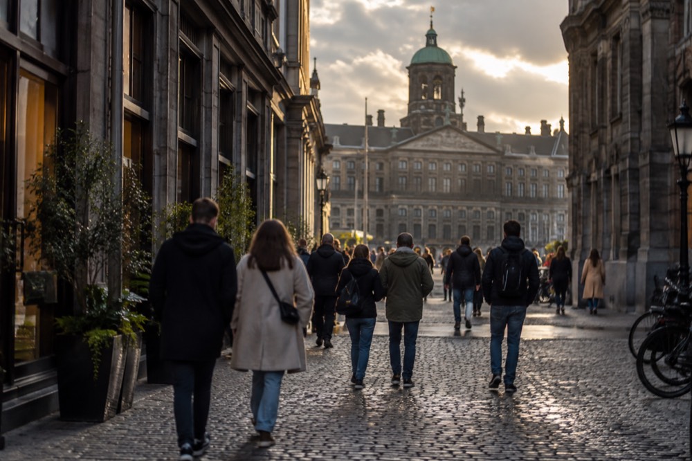 A narrow evening street in the old centre with walkers in small groups
