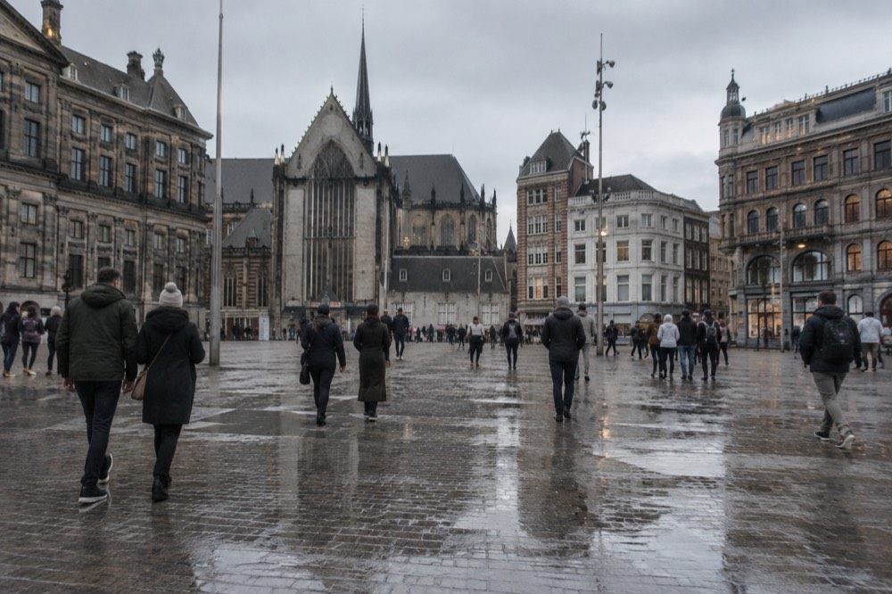 People walking past Dam Square, seen from across the street