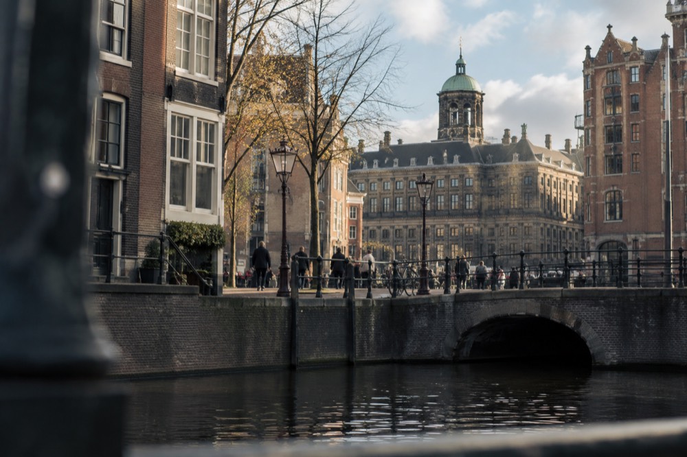 Brick facades and a quiet canal edge beside Dam Square