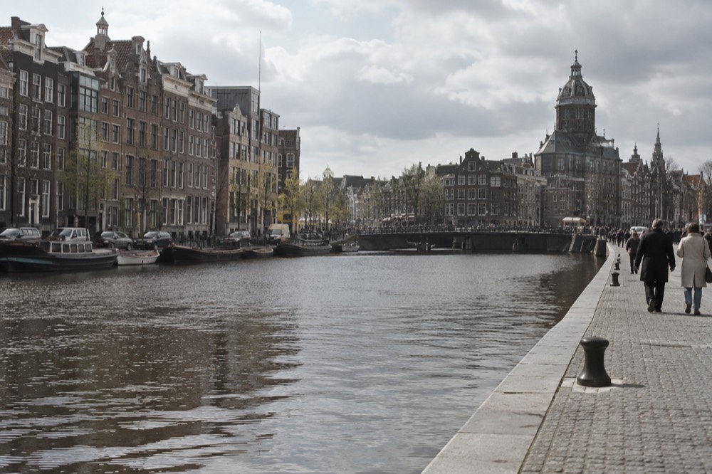 The waterfront near Dam Square under a broad grey northern sky