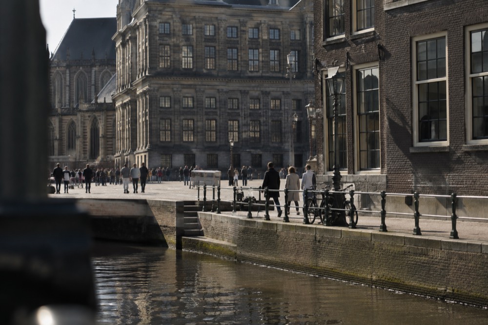 Brick facades and a quiet canal edge beside Dam Square
