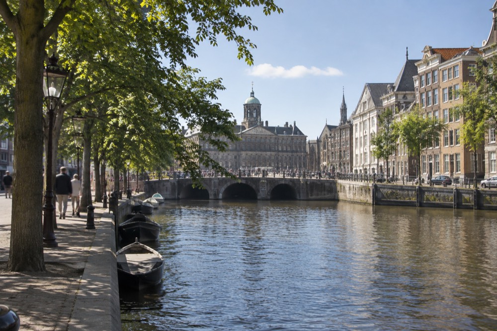 A quiet corner of Dam Square with trees overhanging the water