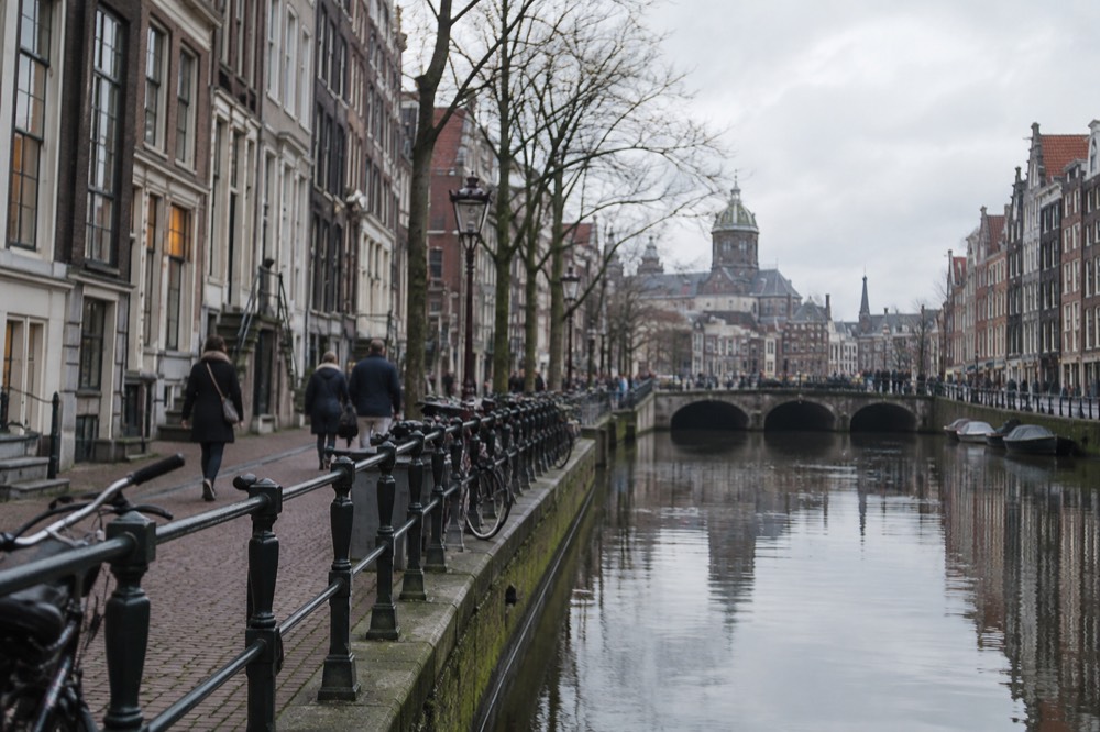 Brick facades and a quiet canal edge beside Dam Square