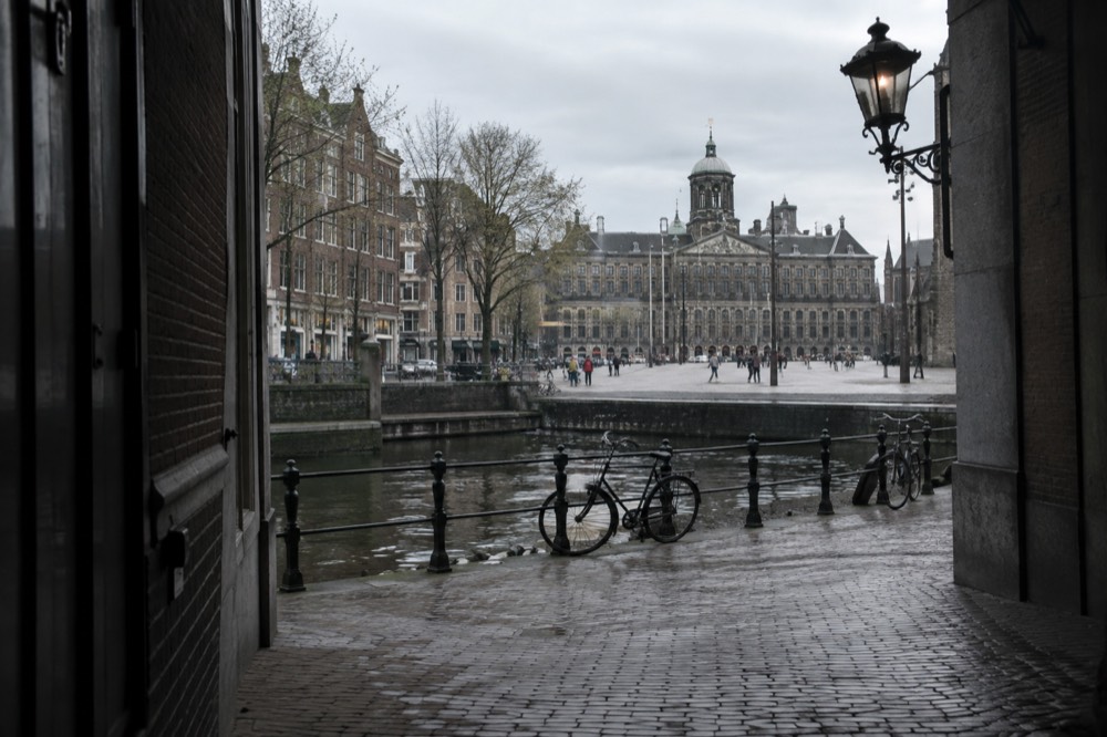 Brick facades and a quiet canal edge beside Dam Square