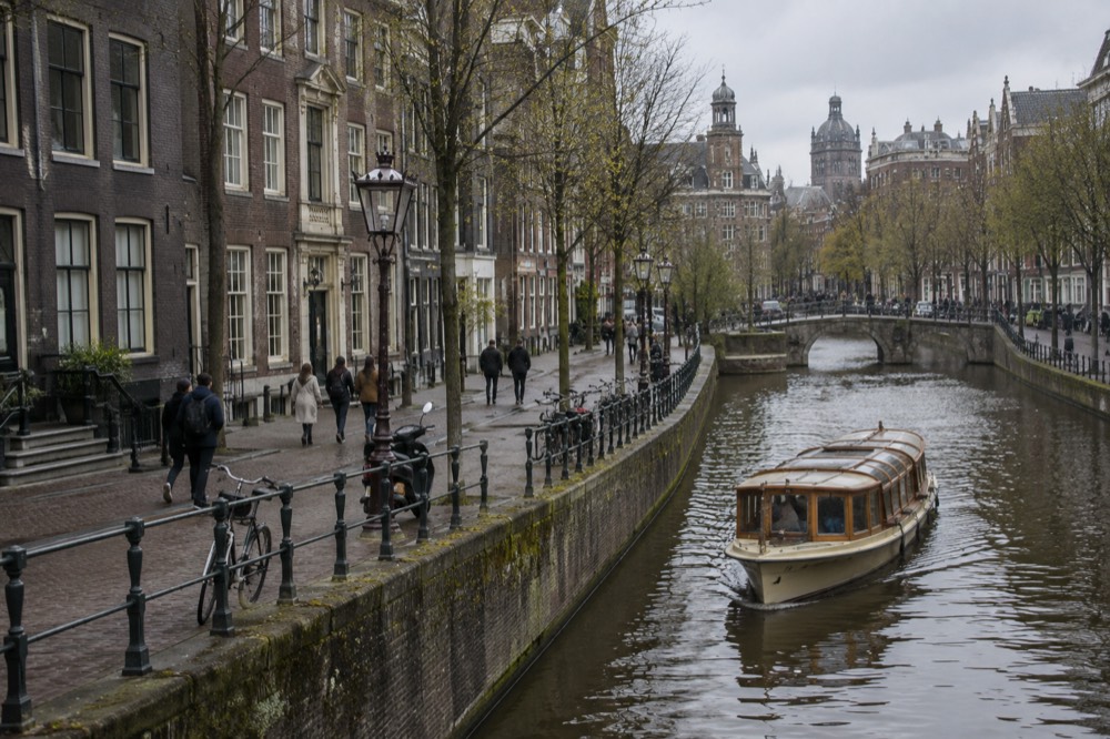 Brick facades and a quiet canal edge beside Dam Square