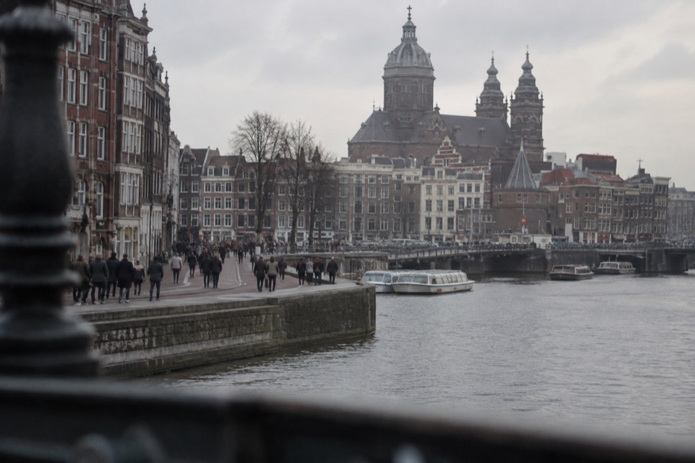 The waterfront near Dam Square under a broad grey northern sky