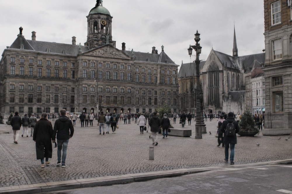 People walking past Dam Square, seen from across the street