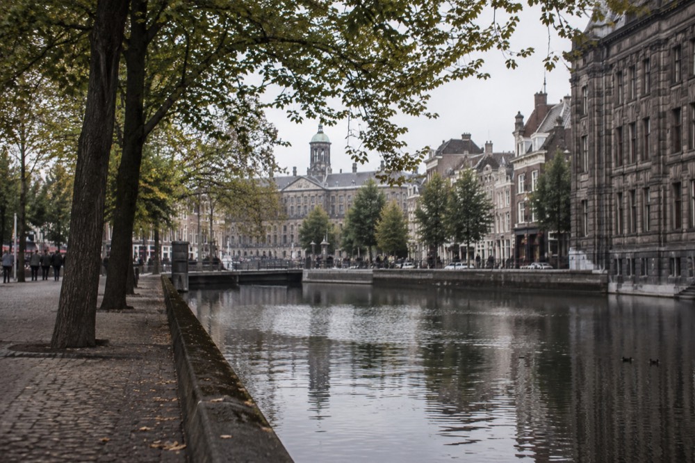 A quiet corner of Dam Square with trees overhanging the water
