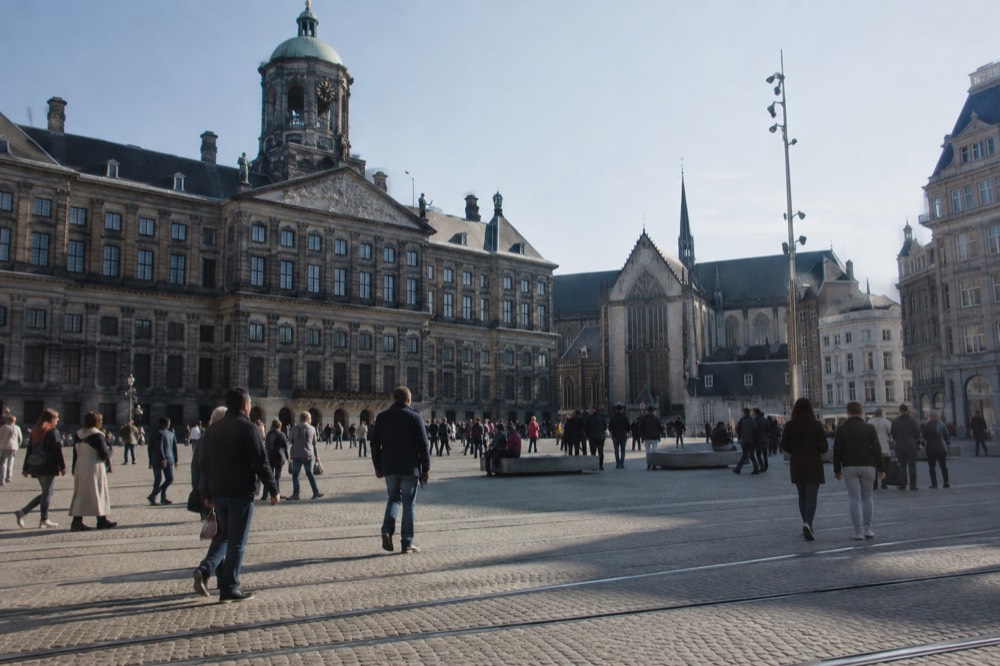 People walking past Dam Square, seen from across the street