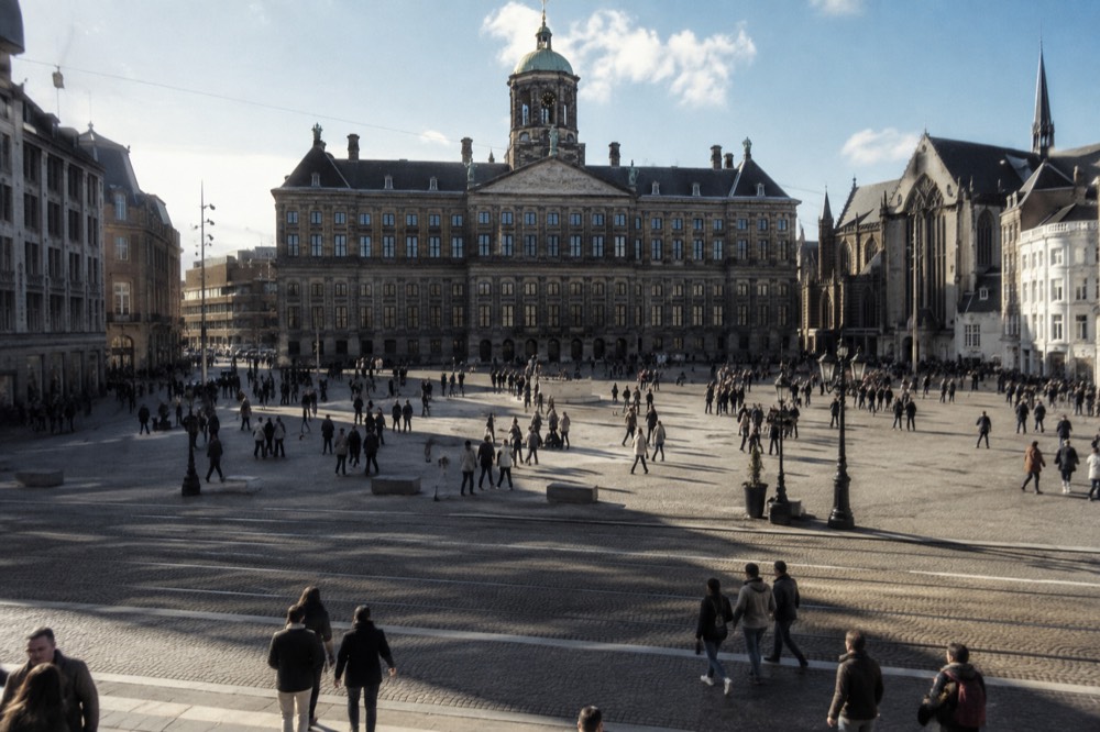 People walking past Dam Square, seen from across the street