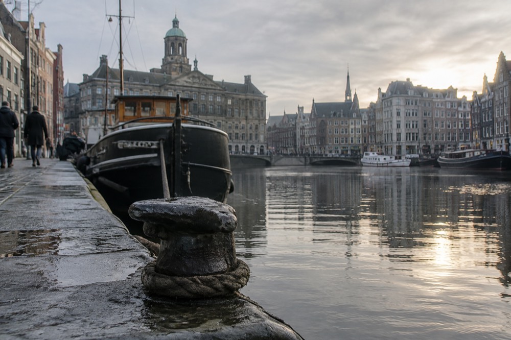 The waterfront near Dam Square under a broad grey northern sky