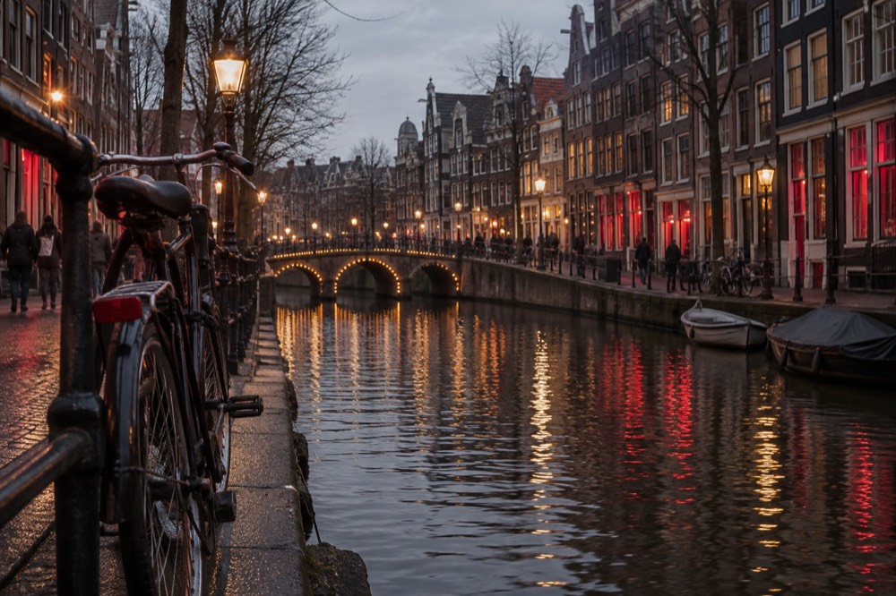 Evening view of a canal in the old centre with narrow brick houses and a lit bridge
