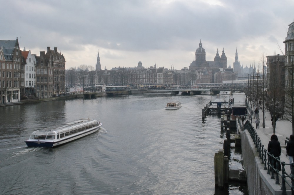 The waterfront near Dam Square under a broad grey northern sky