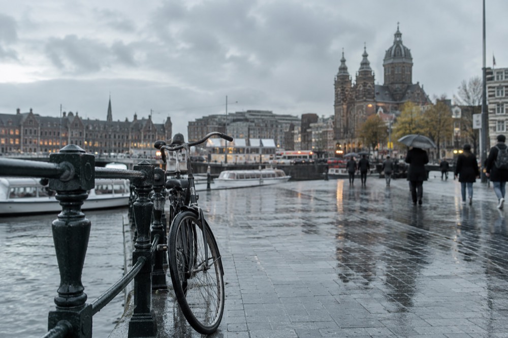 The waterfront near Dam Square under a broad grey northern sky