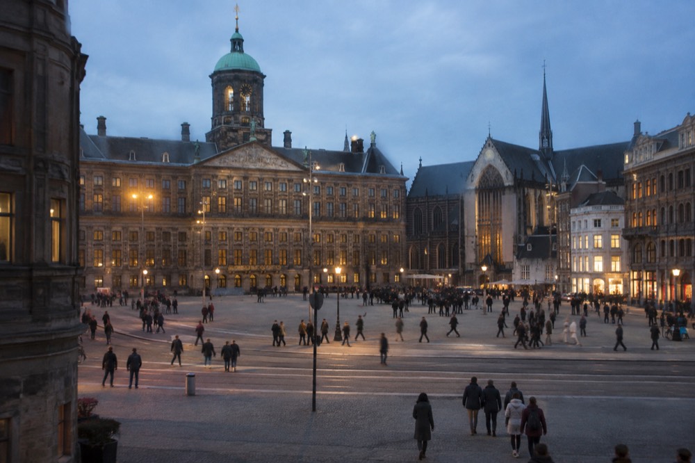 People walking past Dam Square, seen from across the street