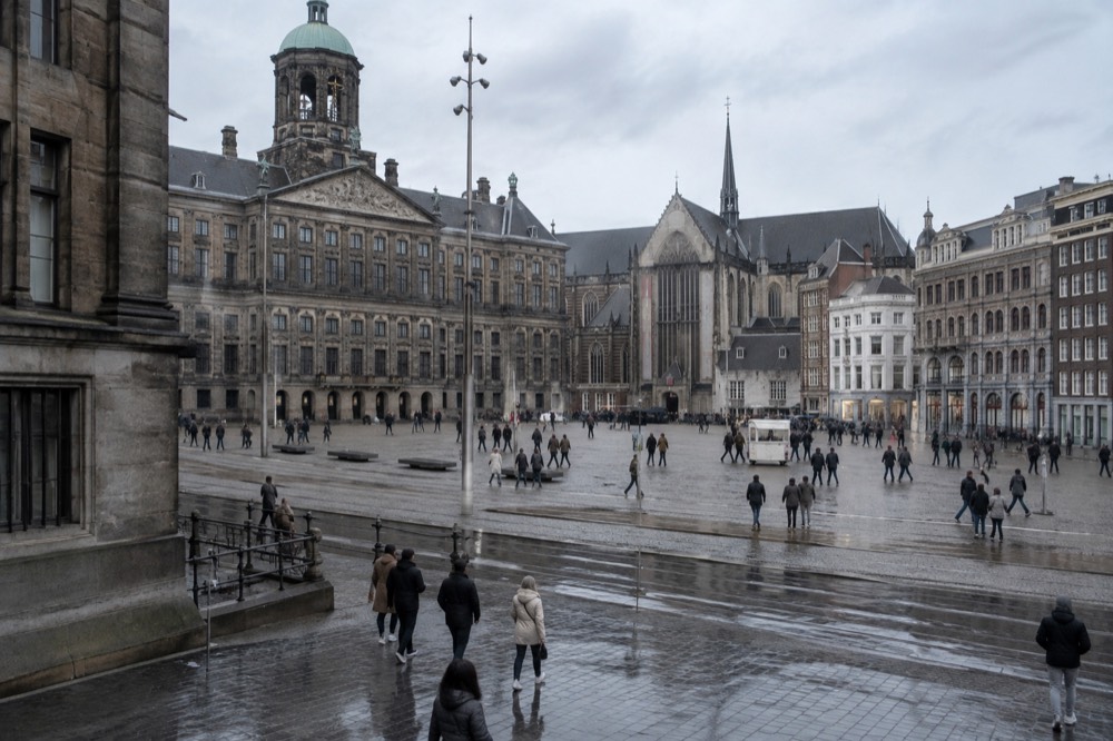 People walking past Dam Square, seen from across the street