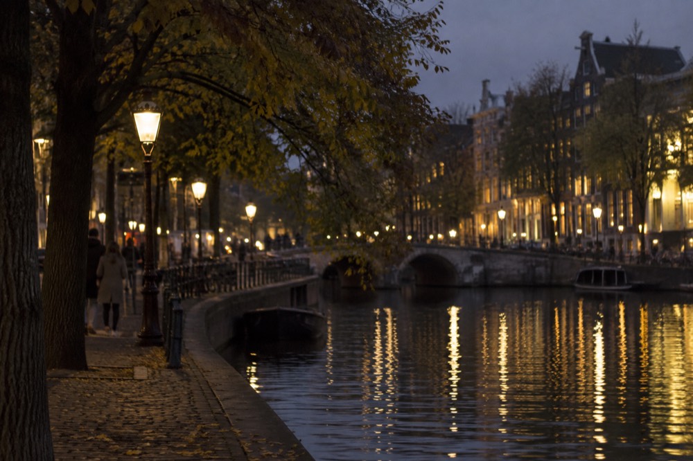 A quiet corner of Dam Square with trees overhanging the water