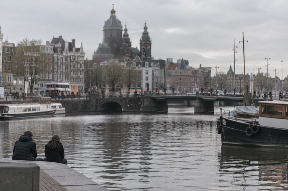 The waterfront near Dam Square under a broad grey northern sky