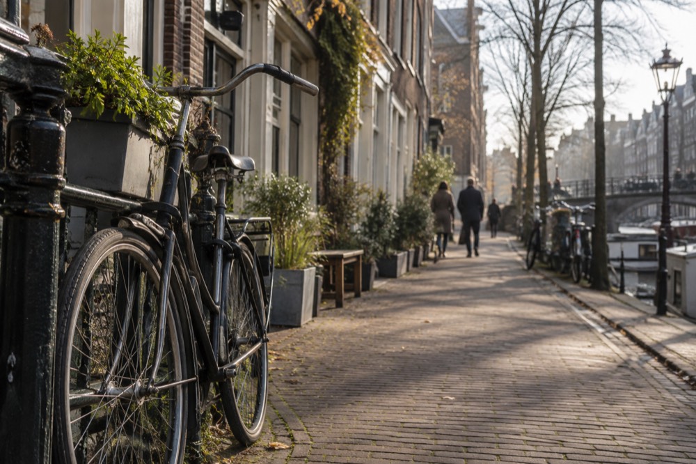 A quiet Jordaan street lined with small shops and bicycles parked against railings