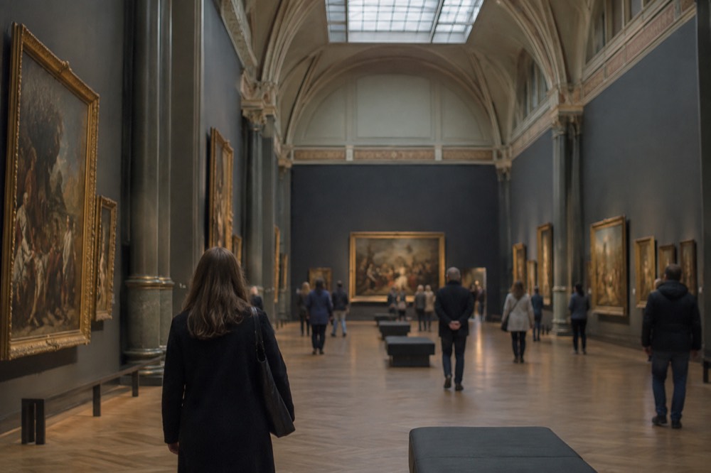 Grand gallery hall inside the Rijksmuseum with paintings lit on the walls