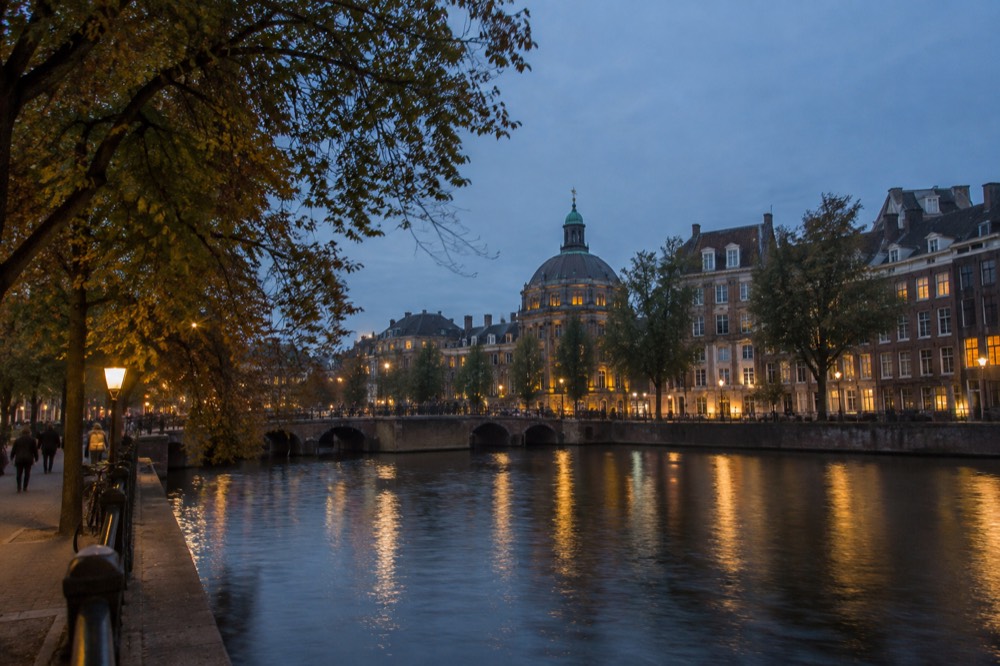 A quiet corner of Dam Square with trees overhanging the water