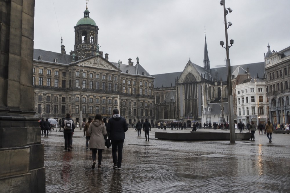 People walking past Dam Square, seen from across the street