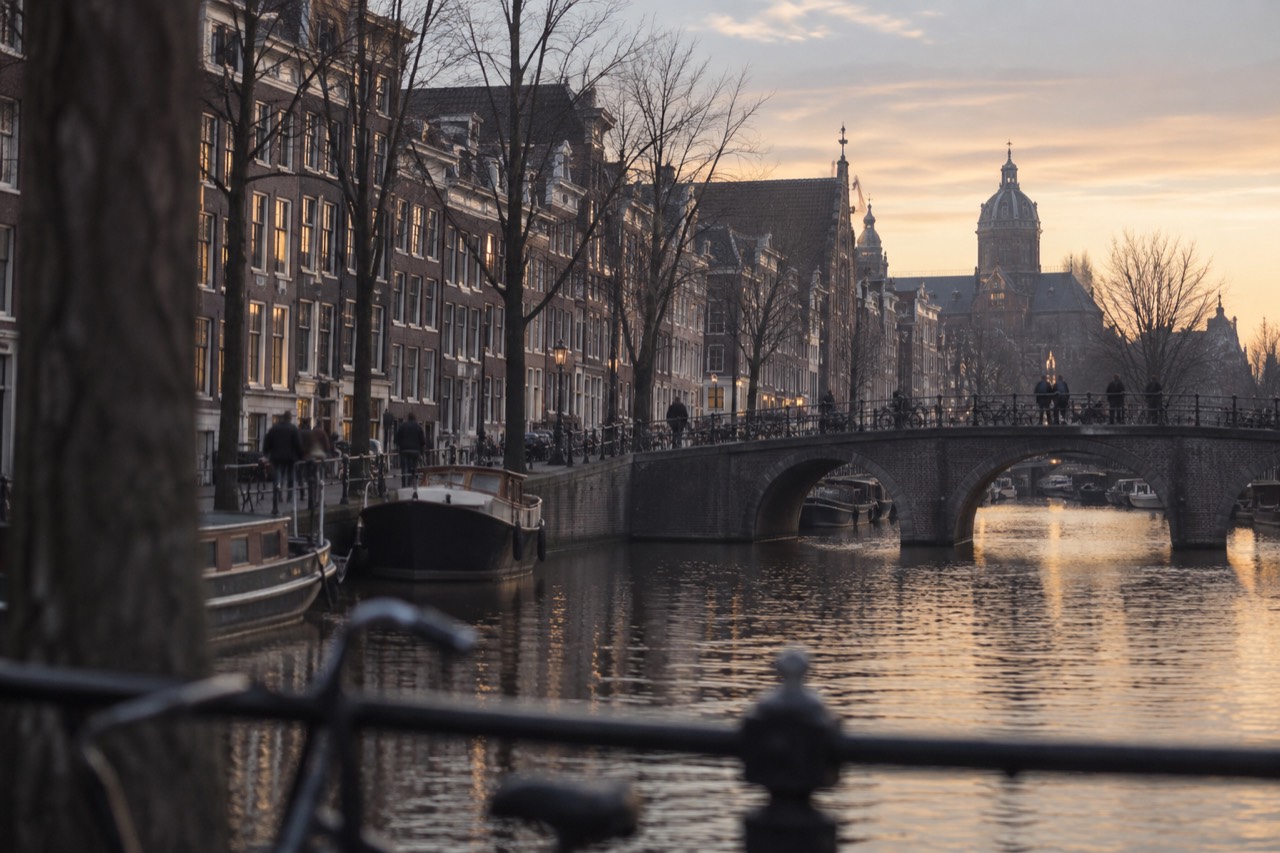 Canal houses and a bridge over an Amsterdam canal at dusk