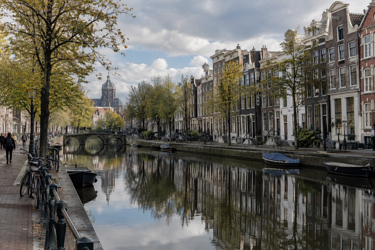 Amsterdam canal houses reflected in still water on a quiet morning